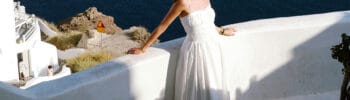 Woman in a white dress overlooking the caldera in Santorini, Greece