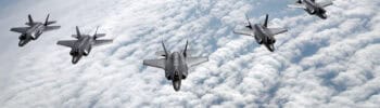 Six U.S. Air Force F-35A Lightning II fighter jets fly in formation above cloud cover.