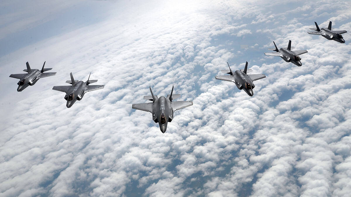 Six U.S. Air Force F-35A Lightning II fighter jets fly in formation above cloud cover.