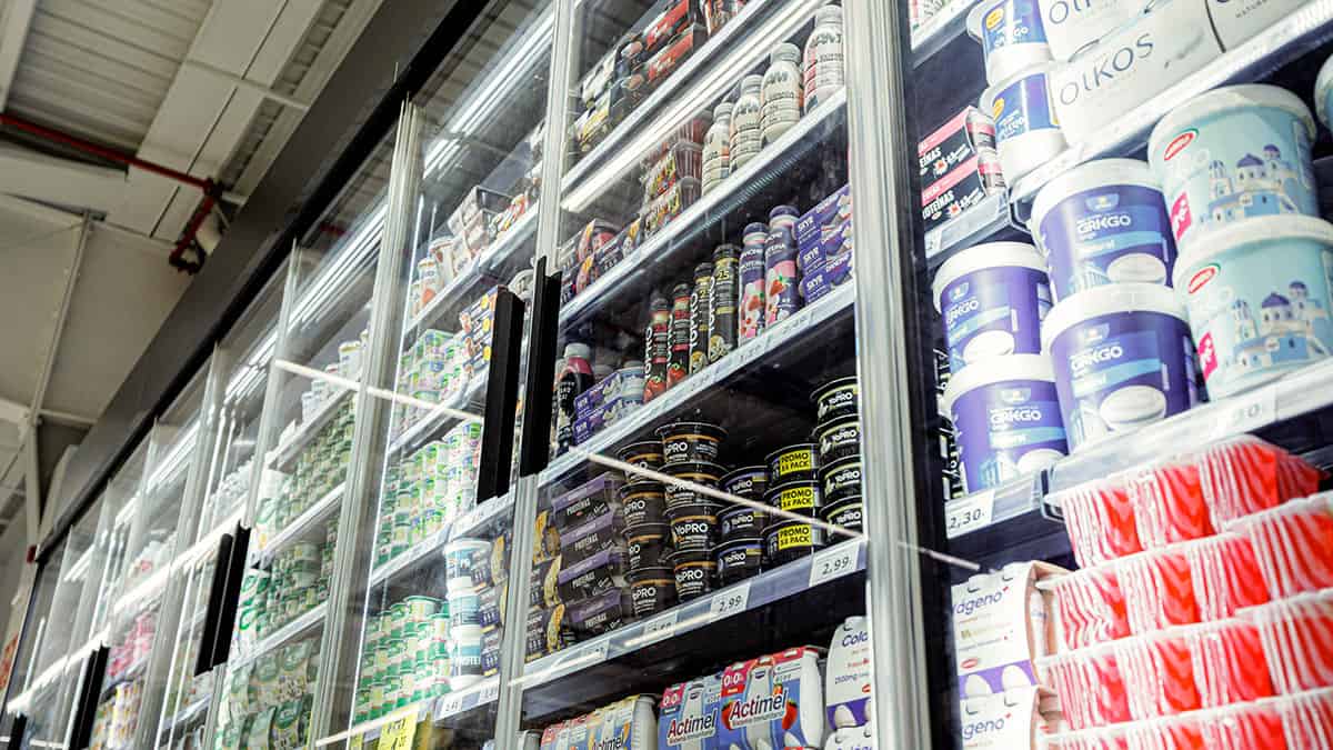 Packaged food products displayed on refrigerated supermarket shelves.