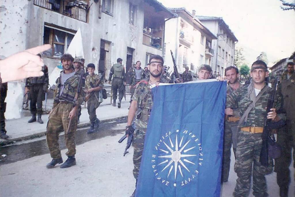 Members of the Greek Volunteer Guard in Srebrenica on July 11, 1995, holding a flag bearing the Vergina Sun.