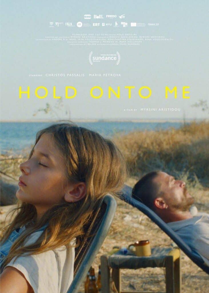 Hold Onto Me film poster showing a young girl and a man seated outdoors by the sea.