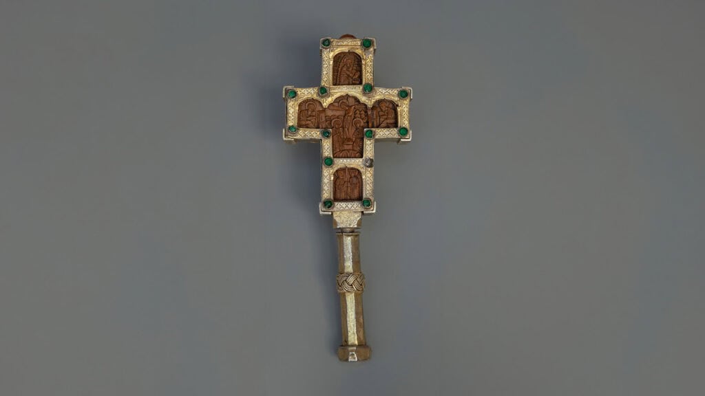 Carved wooden cross with metal covering and green decorative stones, dated 1615.
