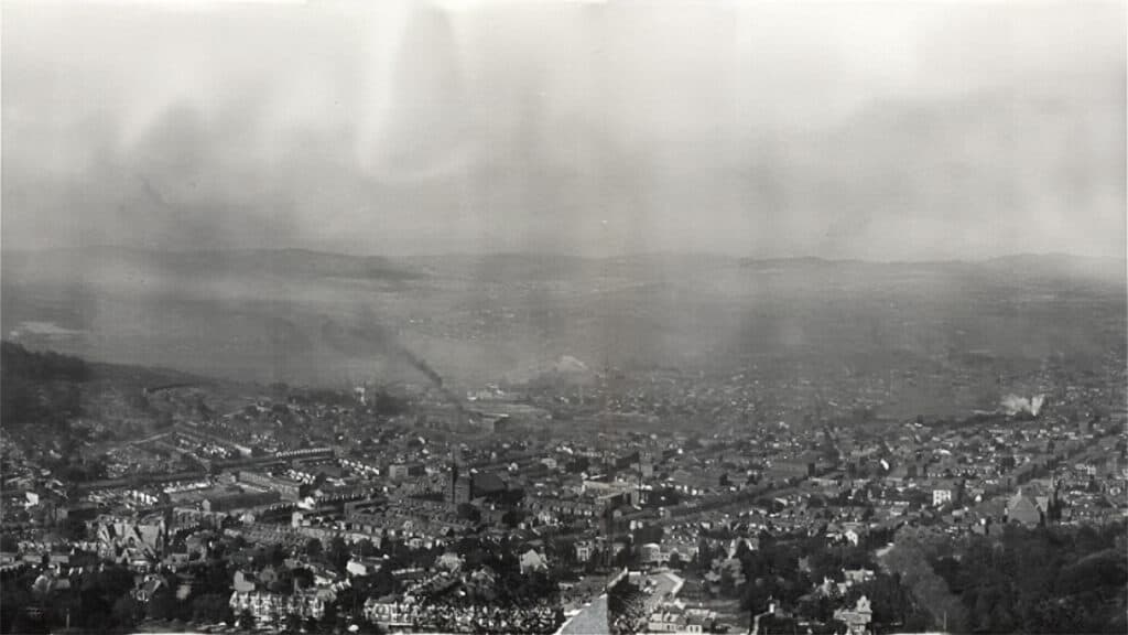 Panoramic photograph of Reading, Pennsylvania, around 1909, showing densely packed rooftops, factories, and hills in the distance.
