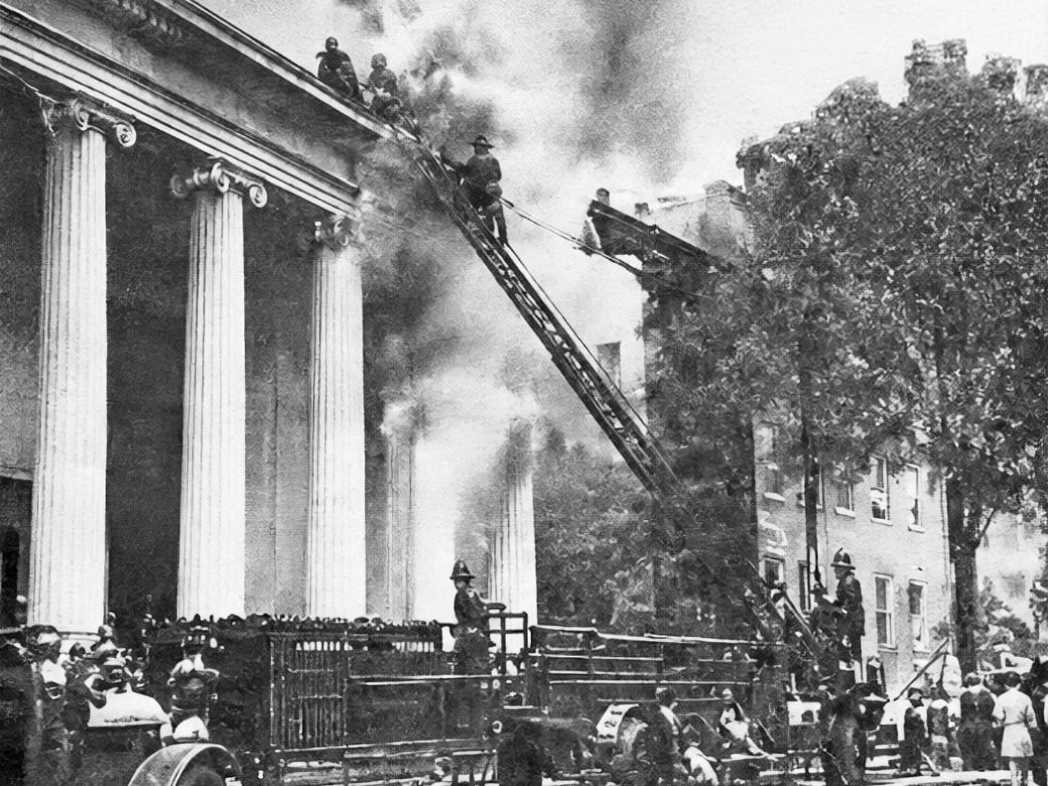 Firefighters on ladders battle the 1930 fire at St. George’s Greek Orthodox church on South Eighth Street in Philadelphia.